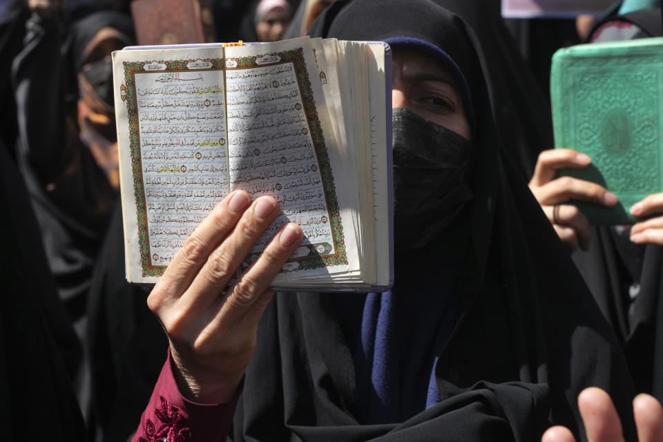 A demonstrator holds up a copy of the Quran, Islam's holy book, during a protest of the burning of a Quran in Sweden, in front of the Swedish Embassy in Tehran, Iran, Friday, June 30, 2023. A Quran burning and a string of requests to approve the destruction of more holy books have left Sweden torn between its commitment to free speech and its respect for religious minorities. The clash of fundamental principles has complicated Sweden's desire to join NATO. Turkey has blocked Swedish accession since last year, citing reasons including anti-Turkish and anti-Islamic protests in Stockholm. (AP Photo/Vahid Salemi)