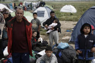 <p>Refugees and migrants wait to board buses during a police evacuation operation at a refugee camp near Idomeni, Greece, on May 24, 2016. (Yannis Kolesidis/AP) </p>