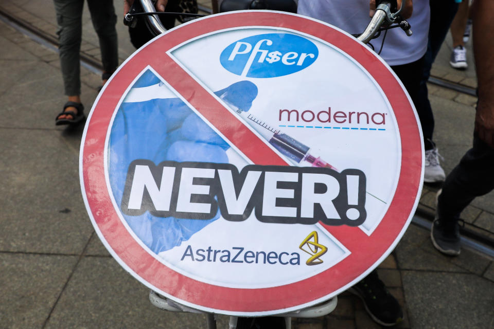 Anti-vaccine sign with "NEVER" written across the logos of vaccine manufacturers