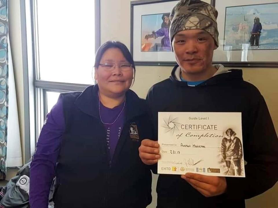 Austin Maniyogena (left) with family friend, Beverly Mala. Witnesses at a coroner's inquest underway in Kugluktuk, Nunavut, said Austin had jumped from a moving bylaw vehicle on the day he died from a head injury.  (Submitted by Jennifer Maniyogena - image credit)