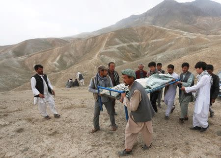 Afghan men carry the coffin of a victim for the burial ceremony a day after a suicide attack in Kabul, Afghanistan July 24, 2016.REUTERS/Omar Sobhani