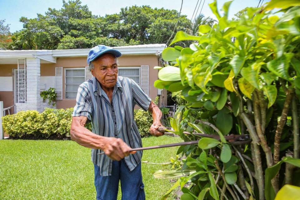 Ann Waiters, de 92 años, una enfermera jubilada, recorta el seto en el patio delantero de su casa de toda la vida en el históricamente afroamericano West Coconut Grove, en Miami, el miércoles 15 de junio de 2022.