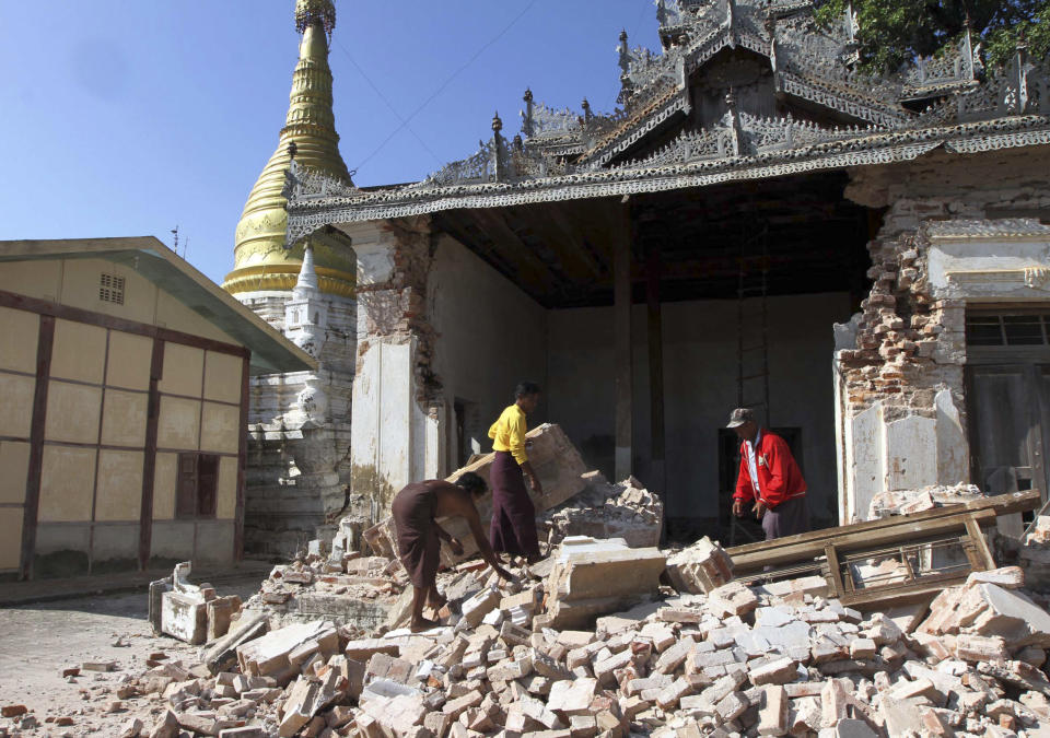 Three men try to clear debris after a pagoda was damaged by Sunday's strong earthquake in Kyaukmyaung township in Shwebo, Sagaing Division, northwest of Mandalay, Myanmar, Monday, Nov. 12, 2012. The earthquake collapsed a bridge and damaged ancient Buddhist pagodas in northern Myanmar, and piecemeal reports from the underdeveloped mining region said mines collapsed and as many as 12 people were feared dead. (AP Photo/Khin Maung Win)