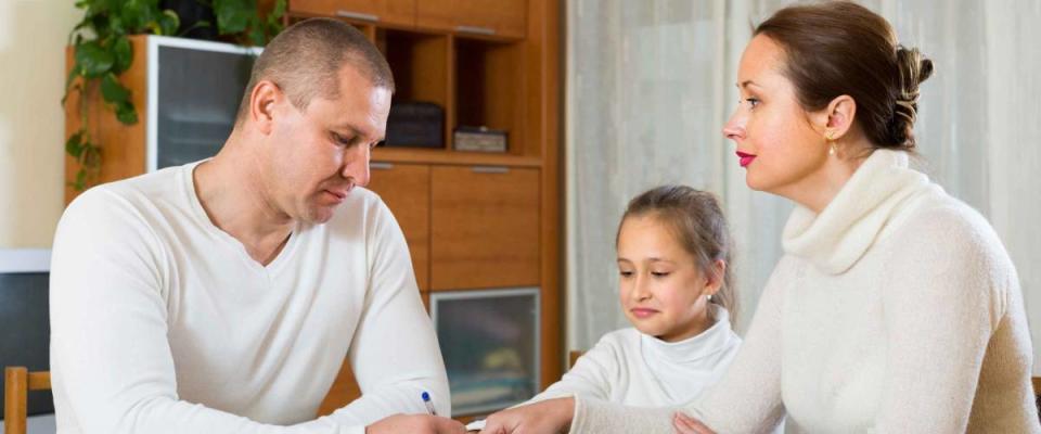 Poor family counting money to pay bills at the table at home