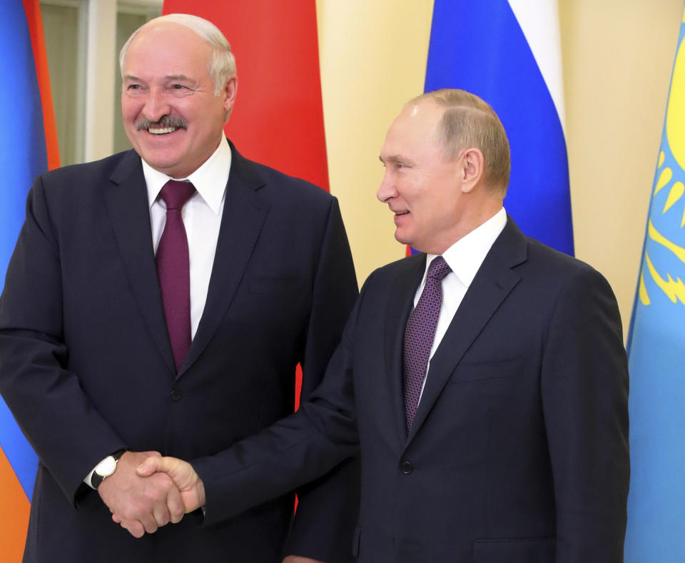 Russian President Vladimir Putin, right, and Belarusian President Alexander Lukashenko shake hands during a meeting in St. Petersburg, Russia, Friday, Dec. 20, 2019. The presidents of Russia and Belarus are holding talks on expanding ties between the two ex-Soviet neighbors and allies. (Mikhail Klimentyev, Sputnik, Kremlin Pool Photo via AP)