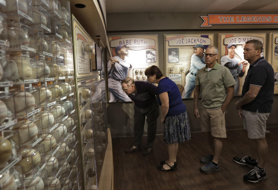 Visitors to the St. Petersburg Museum of History view some of Dennis Schraders autographed baseballs Tuesday, Oct. 22, 2013, in St. Petersburg, Fla. New York Yankees legend Mickey Mantle signed a baseball for Schrader in 1956, when Schrader was a 9-year-old boy attending a spring training game in Florida, leading to a lifelong obsession: He now has more than 4,600 signed baseballs, certified by Guinness as the largest such collection in the world. (AP Photo/Chris O'Meara)