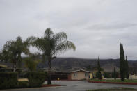 Fog rolling over hills is seen from a street in the San Jerardo cooperative in Salinas, Calif., Wednesday, Dec. 20, 2023. Some California farming communities have been plagued for years by problems with their drinking water due to nitrates and other contaminants in the groundwater that feeds their wells. (AP Photo/Jeff Chiu)