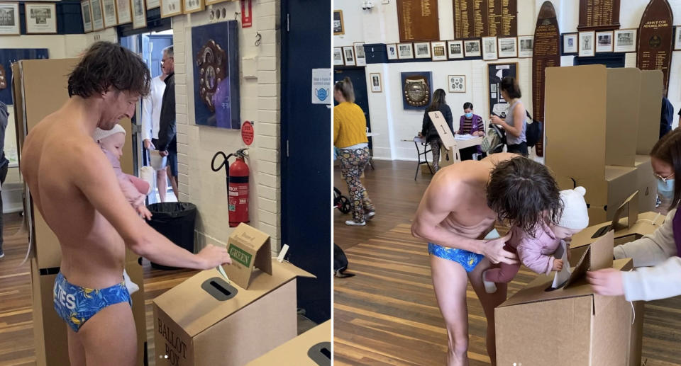 Jim Finn votes in budgie smugglers with his daughter in his arms