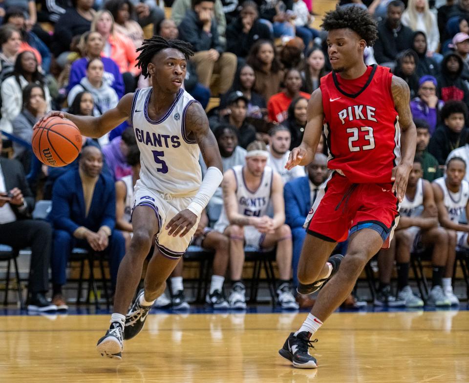 Ben Davis High School senior Sheridan Sharp (5) drives the ball along the baseline while being defended by Pike High School junior Camron Casky (23) during the second half of an IHSAA Sectional basketball game, Saturday, March 4, 2023, at Perry Meridian High School. Ben Davis won 80-59.