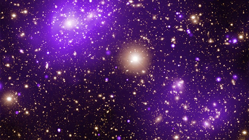 Neon purple gas clouds imaged by Chandra in X-ray light glow in an image of the Abell 2125 galaxy cluster. - Chandra X-ray Observatory Center/NASA