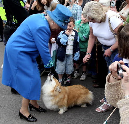 Even Queen Elizabeth II can’t resist sharing food with her adorable corgis