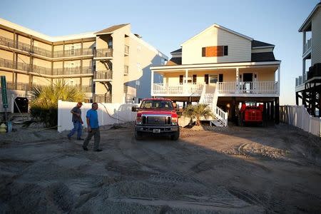 People check on their property after several feet of sand was carried by the storm surge of Hurricane Matthew in Garden City Beach, South Carolina, U.S. October 9, 2016. REUTERS/Randall Hill