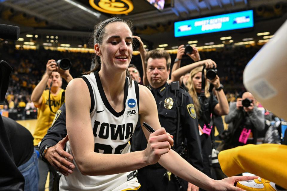 Iowa Hawkeyes guard Caitlin Clark (22) signs autographs after the NCAA second round game against West Virginia.