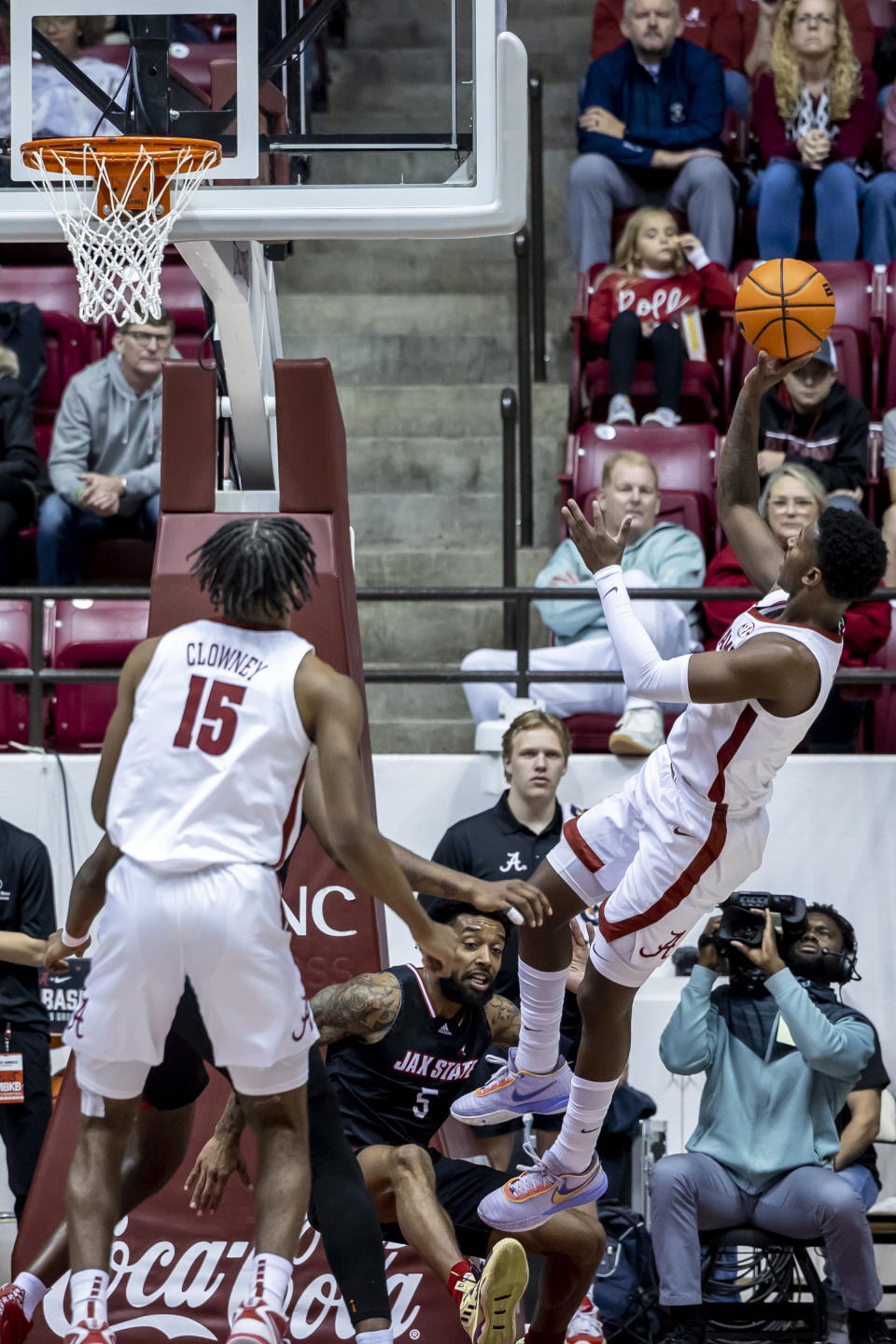 Alabama guard Jaden Bradley, right, shoots a fadeaway jump shot as Jacksonville State guard Skyelar Potter (5) falls away on defense during the first half of an NCAA college basketball game, Friday, Nov. 18, 2022, in Tuscaloosa, Ala. Alabama forward Noah Clowney (15) looks on. (AP Photo/Vasha Hunt)