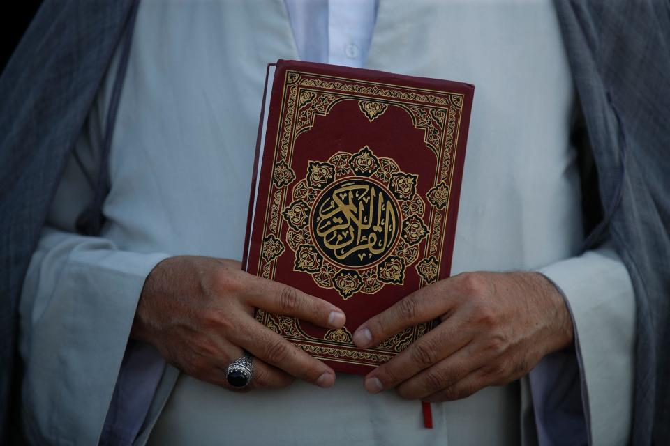 A cleric holds a Quran outside the Swedish Embassy in Baghdad, Iraq, during a protest on June 30, 2023, against the burning of a Quran outside a Stockholm mosque. / Credit: AHMAD AL-RUBAYE/AFP/Getty