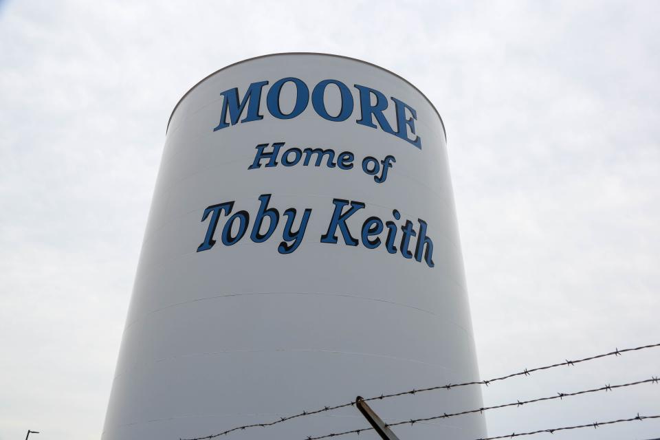 A Moore water tower is emblazoned with the logo "Home of Toby Keith."