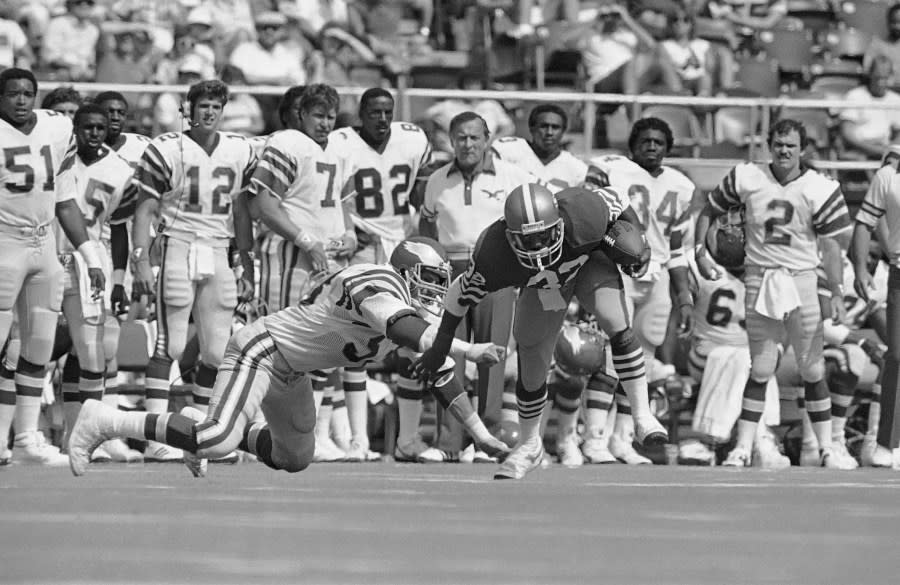 San Francisco 49ers’ Carl Monroe scrambles to evade a tackle by Philadelphia Eagles’ Jody Schulz during first quarter NFL action at Philadelphias Veterans Stadium on Sept. 23, 1984. (AP Photo/Peter Morgan)