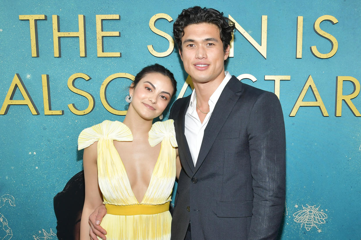 A photo of Camila Mendes wearing a yellow dress and Charles Melton wearing a grey suit at the world premiere of Warner Bros "The Sun Is Also A Star" at Pacific Theaters at the Grove on May 13, 2019 in Los Angeles, California.