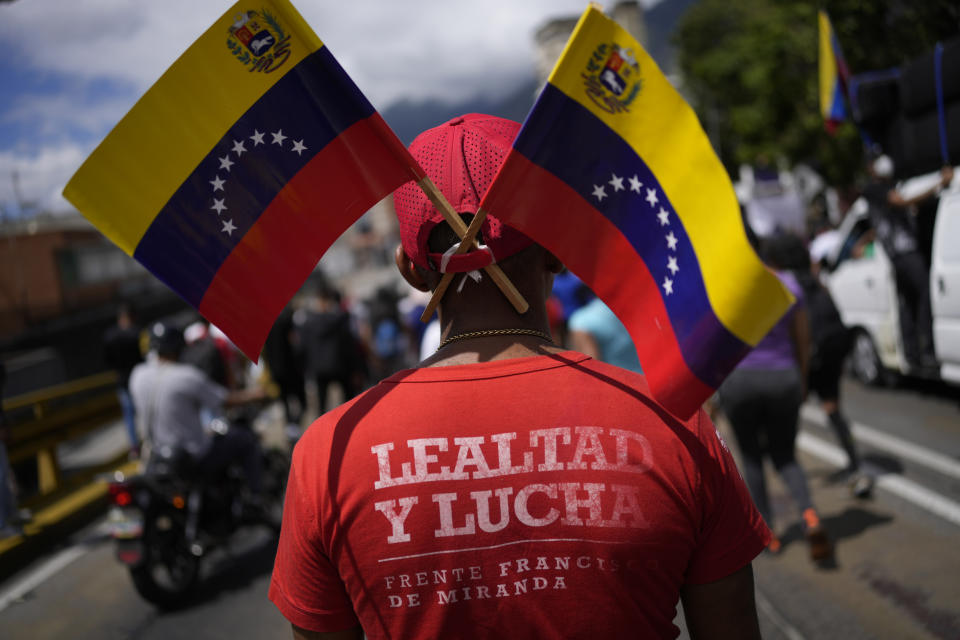 A government supporter, wearing a T-shirt with a message that reads in Spanish: "Loyalty and struggle", takes part in a march marking Youth Day, in Caracas, Venezuela, Saturday, Feb. 12, 2022. The annual holiday commemorates the young people who accompanied heroes in the battle for Venezuela's independence. (AP Photo/Matias Delacroix)
