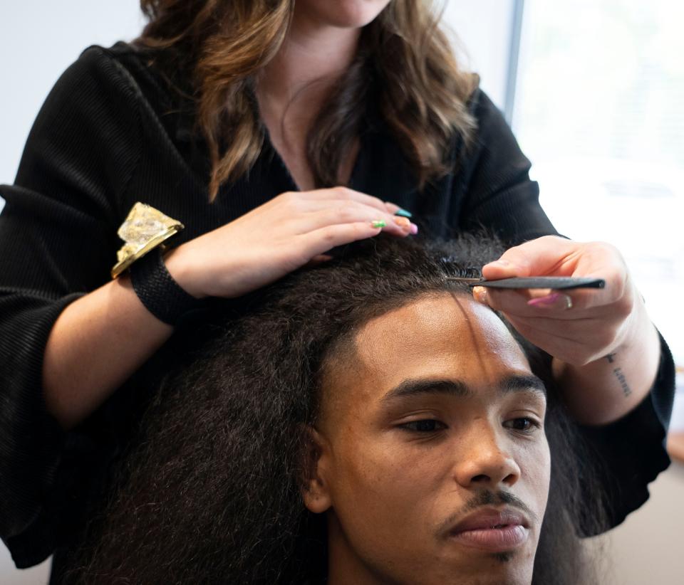 Davin Juerling works with her client Kendrick Murphy on Thursday, Aug. 24, 2023 at Juerling’s Twelve 19 Salon in Indianapolis. She starts by drawing a clean part down the exact center of his head.