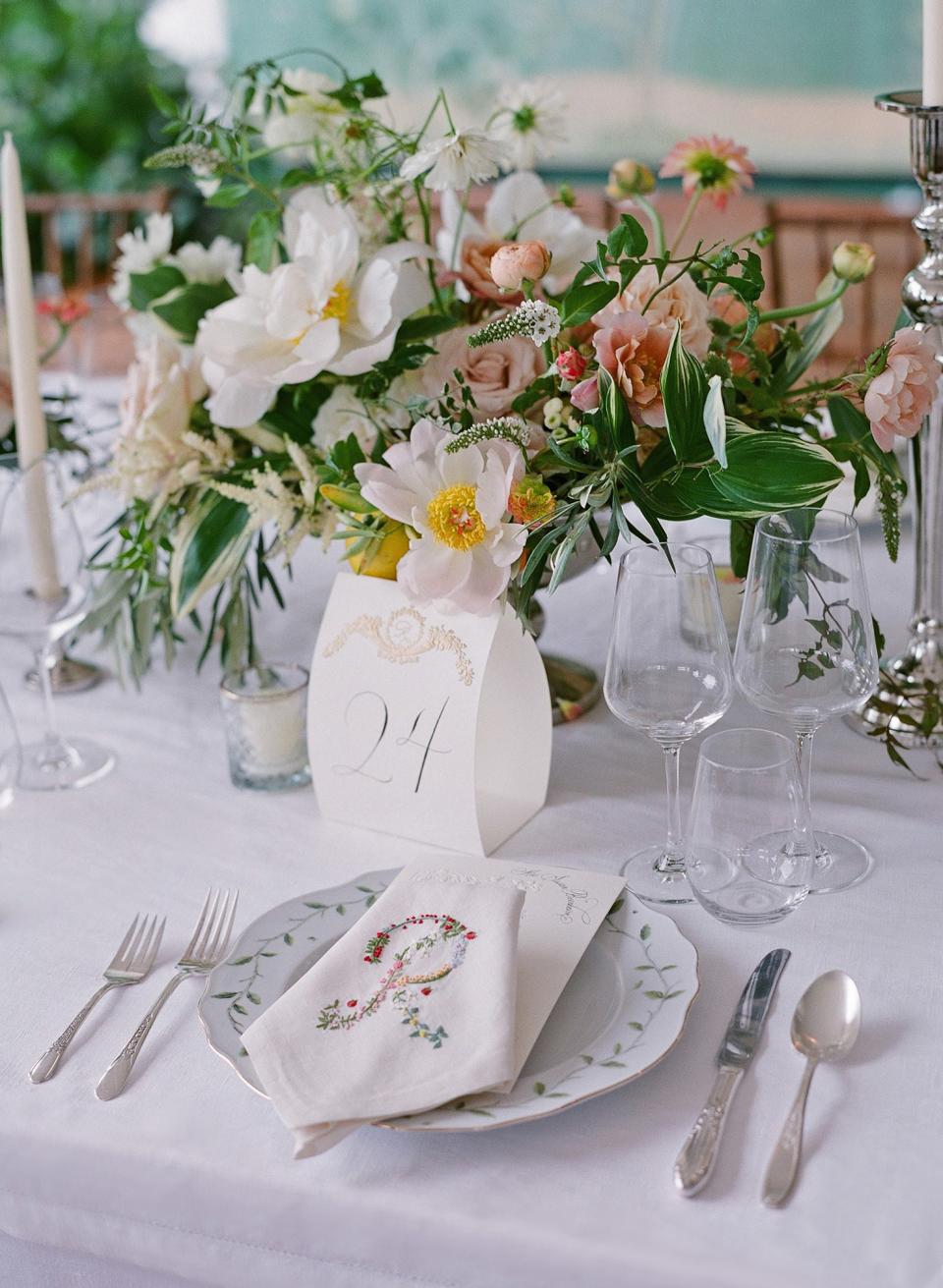 Inspired by the romanticism of the lush gardens, we loved the idea of embroidering the linens with a floral R, and our menus were embossed with lily of the valley.