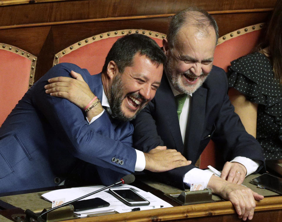 Italian Interior Minister and Deputy-Premier Matteo Salvini, left, laughs as he sits beside The League party's Roberto Calderoli, at the Senate in Rome, Tuesday, Aug. 13, 2019. Italy’s political leaders scrambled to line up allies and form alliances Tuesday as the country’s right-wing interior minister pressed his demands for an early election in the hope of snagging the premiership as a platform for his anti-migrant, euroskeptic agenda. Senators hastily summoned back from a vacation break convened for a vote on scheduling their consideration of a no-confidence motion lodged by Matteo Salvini’s League party against Premier Giuseppe Conte’s 14-month-old populist government. (AP Photo/Alberto Pellaschiar)