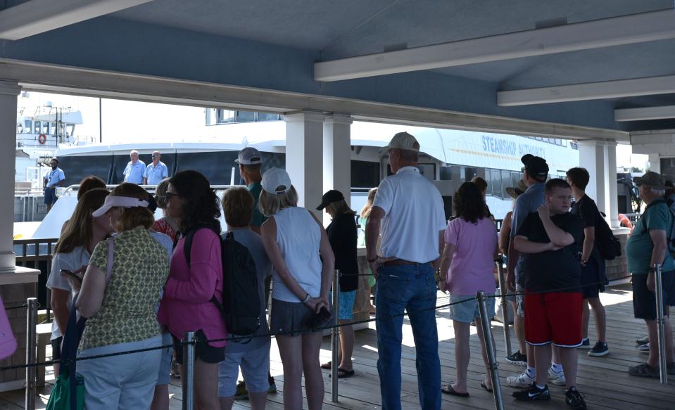 Some of the 240 passengers for the 11 a.m. boat on Wednesday queue up as the ferry Iyanough arrives from Nantucket at the Woods Hole, Martha's Vineyard and Nantucket Steamship Authority terminal in Hyannis.