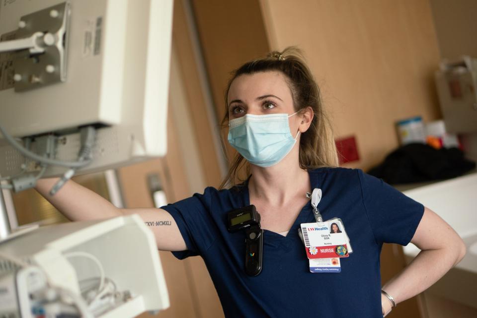 UW Health nurse Olivia Robertson checks a monitor in a patient's room.