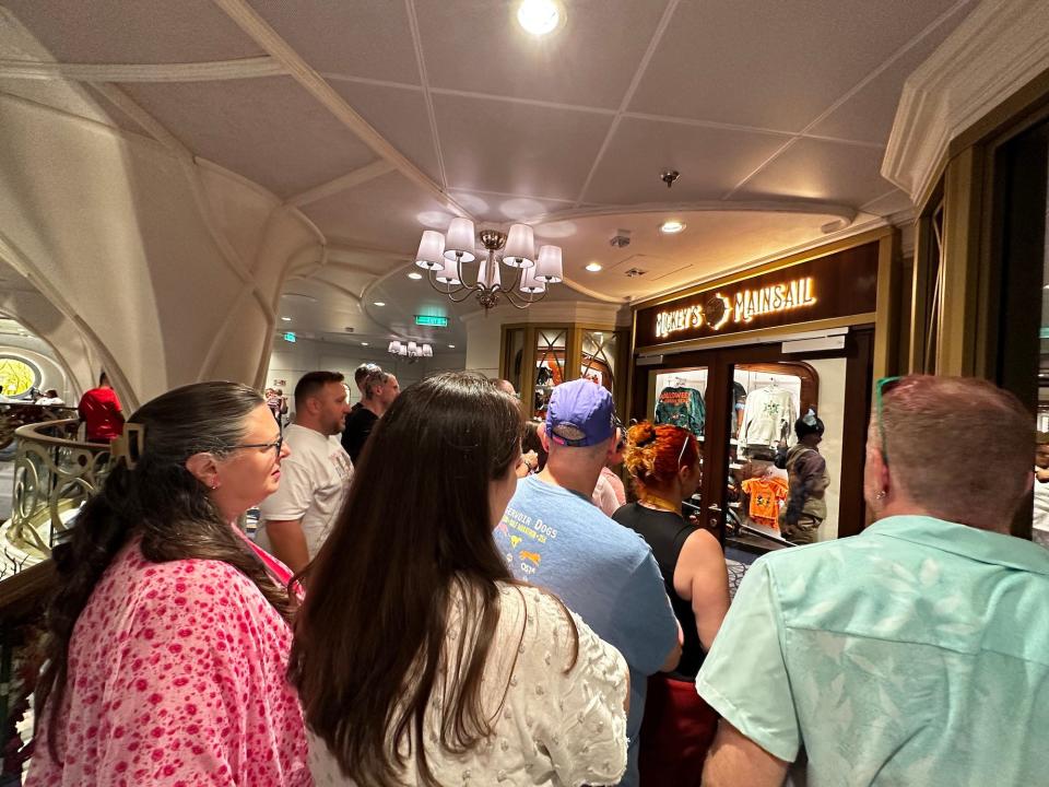 A crowd waits to buy Halloween merchandise onboard the Disney Wish.