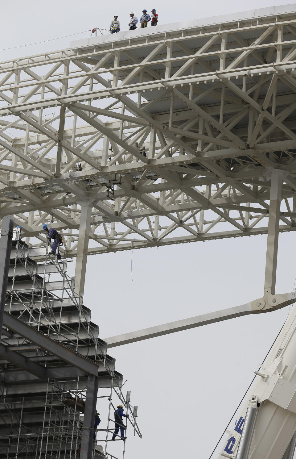 Laborers work on the construction of the Itaquerao stadium in Sao Paulo, Brazil, Tuesday, April 22, 2014. FIFA Secretary General Jerome Valcke said Tuesday there's still a lot of work to do at the stadium, but added that it will be ready for the opening match between Brazil and Croatia in June. (AP Photo/Andre Penner)