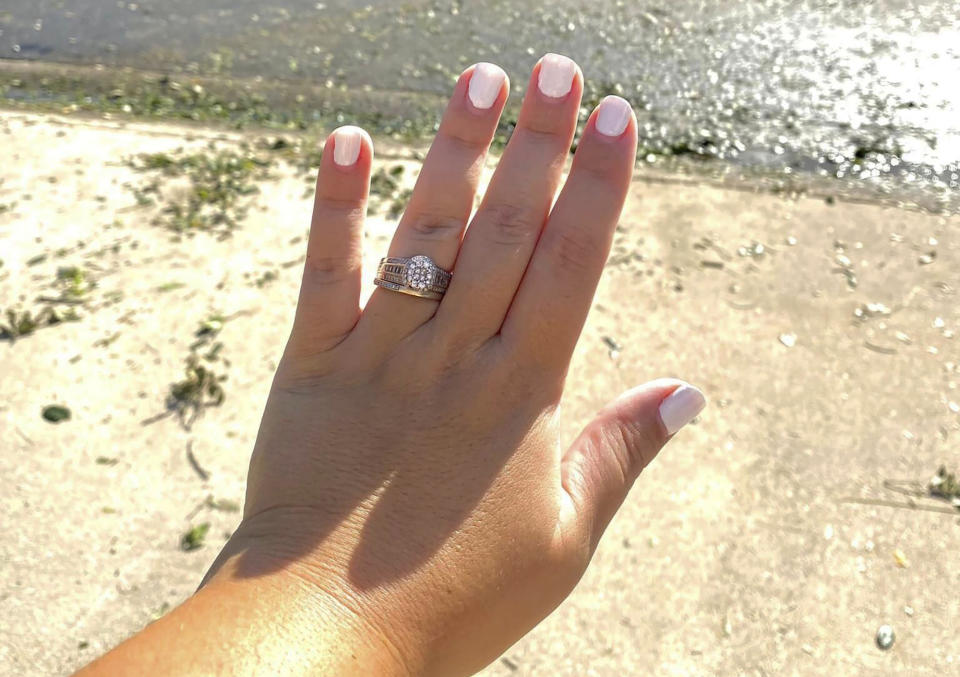 In this undated photo provided by Ashley Garner, Garner shows off her wedding ring that was found lying in a brush pile after Hurricane Ian passed through the area, in Fort Myers, Fla. (Ashley Garner via AP)