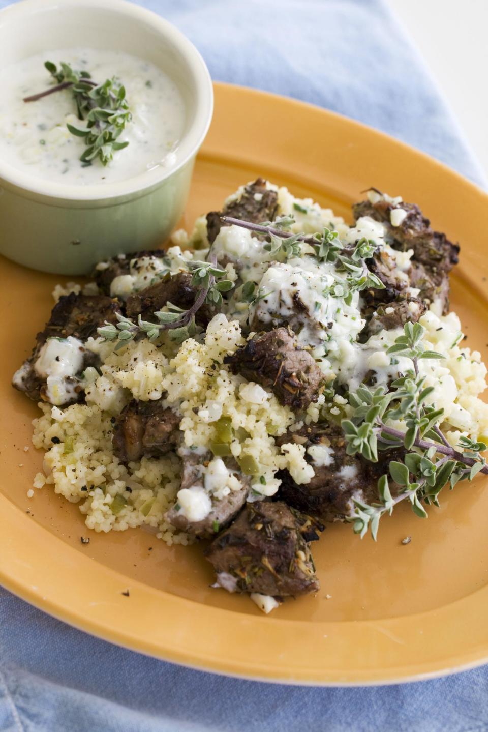 This image taken on April 22, 2013, shows lemon-garlic lamb kebabs with bell pepper couscous served on a plate in Concord, N.H. (AP Photo/Matthew Mead)