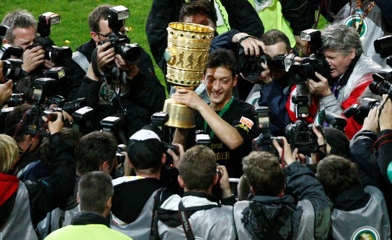 FILE PHOTO: Werder Bremen's Mesut Ozil celebrates with the German Cup after scoring the only goal to secure a 1-0 win in the final against Bayer Leverkusen in Berlin.