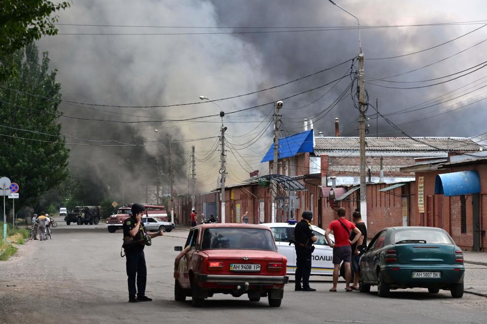 Security forces halt motorists as smoke rises from the central market of Slovyansk after a strike on Tuesday (AFP/Getty)