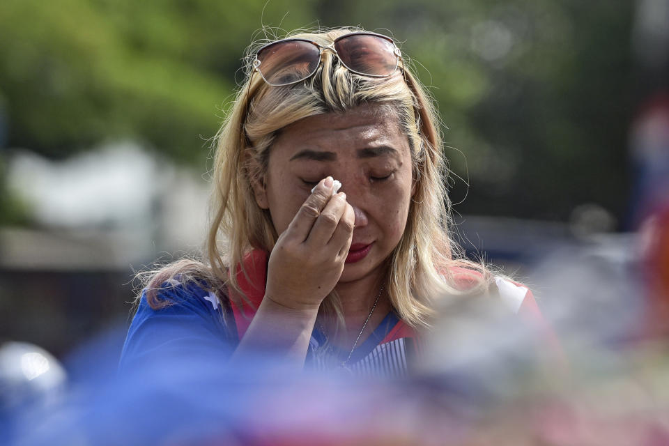 A woman weeps as she offers prayer outside Kanjuruhan Stadium where a soccer stampede killed more than 100 people on Saturday, in Malang, East Java, Indonesia, Tuesday, Oct. 4, 2022. An Indonesian police chief and nine elite officers were removed from their posts Monday and 18 others were being investigated for responsibility in the firing of tear gas inside a soccer stadium that set off a stampede, officials said. (AP Photo/Dicky Bisinglasi)