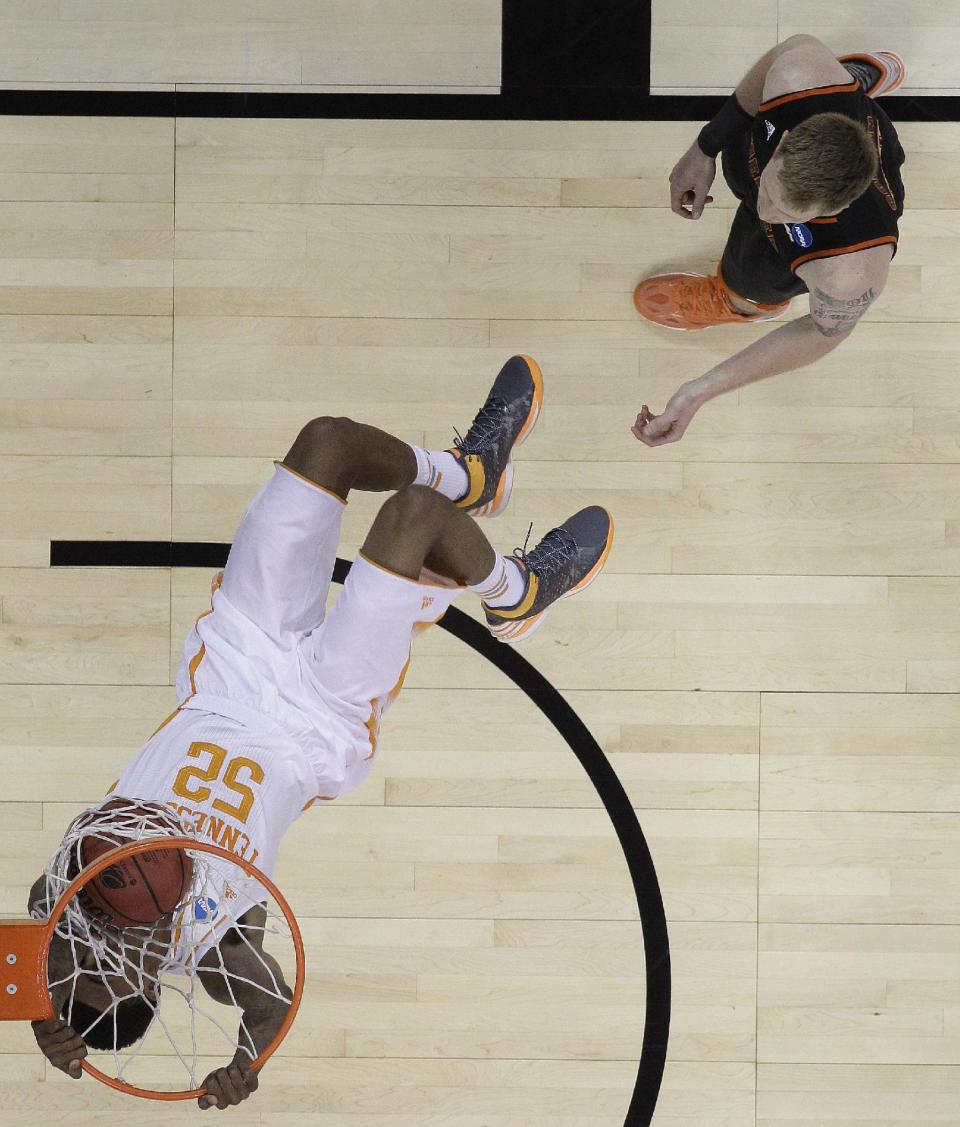 Tennessee guard Jordan McRae (52) dunks against Mercer forward Jakob Gollon (20) during the first half of an NCAA college basketball third-round tournament game, Sunday, March 23, 2014, in Raleigh. (AP Photo/Chuck Burton)