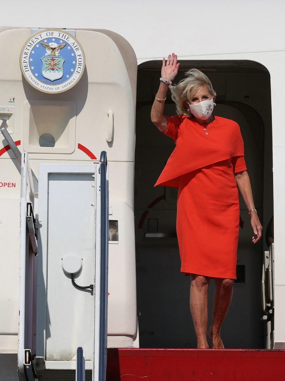 Jill Biden arrives in Tokyo wearing a red dress.