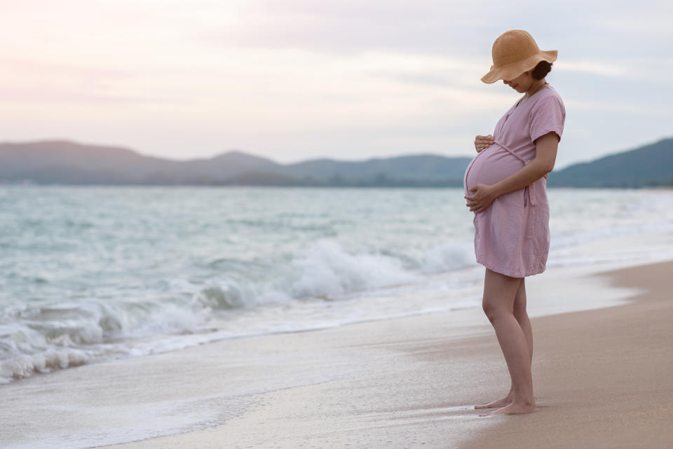 Pregnant woman on beach. (Getty Images)