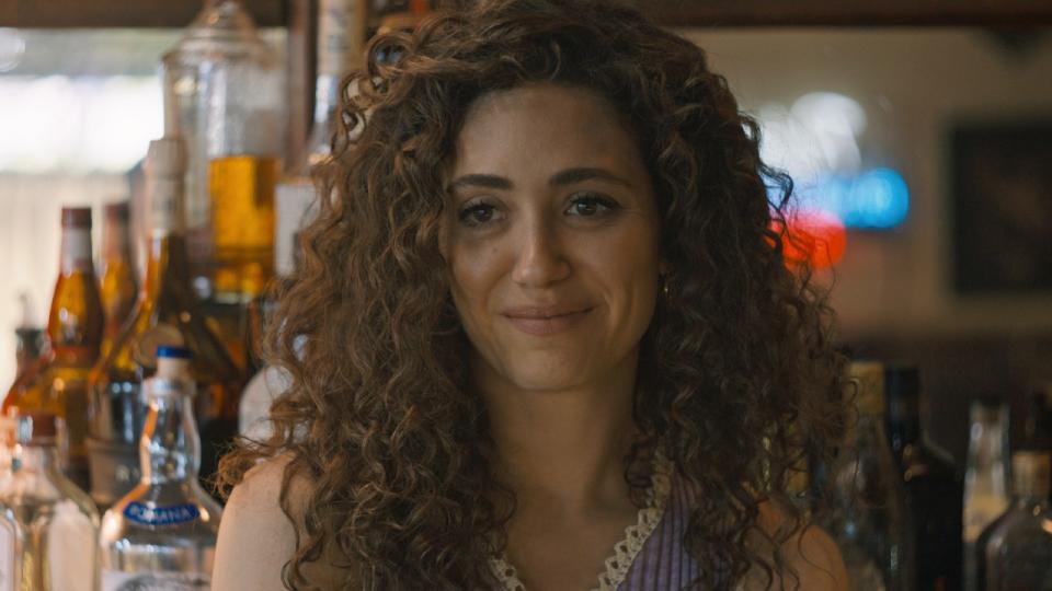 Emmy Rossum standing behind a bar in The Crowded Room.