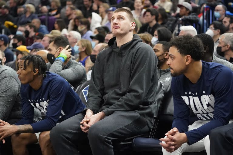 Nikola Jokic, lesionado, en el banco de suplentes de Denver, entre Bones Hyland y Bryn Forbes