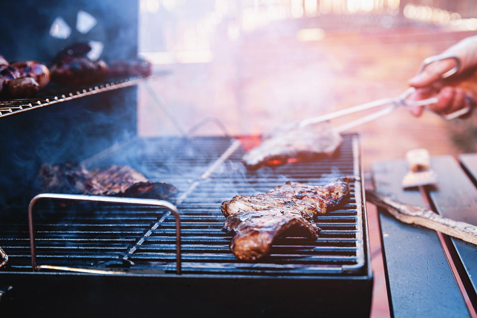 Close up of beef steaks cooking on grill in backyard barbecue. Photo: Getty Images.