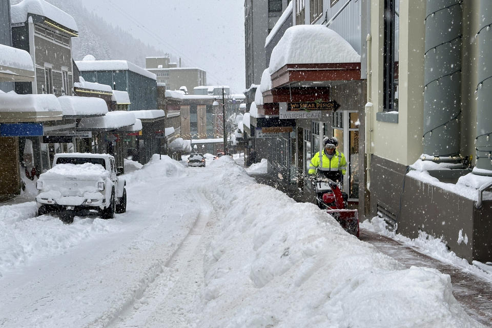 A man uses a snowblower along a downtown sidewalk in Juneau, Alaska, on Tuesday, Jan. 23, 2024. Juneau has received more than 55 inches of snow so far in January, far above the normal level of 24.5 inches, according to the National Weather Service. (AP Photo/Becky Bohrer)