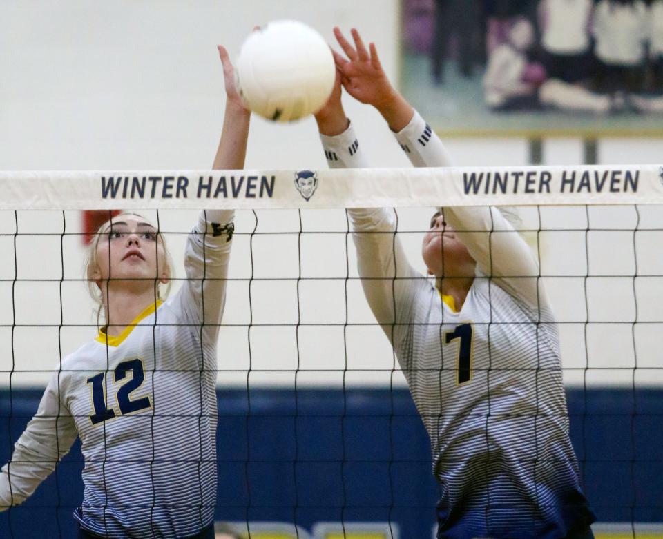 Winter Haven's Paige Prather (12) and Rylee Tanner (7) put down a block against George Jenkins.