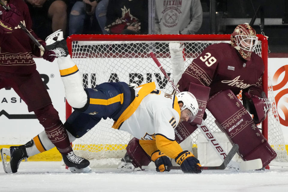 Nashville Predators center Colton Sissons, left, gets shoved into Arizona Coyotes goaltender Connor Ingram (39) during the first period of an NHL hockey game Saturday, Jan. 20, 2024, in Tempe, Ariz. (AP Photo/Ross D. Franklin)