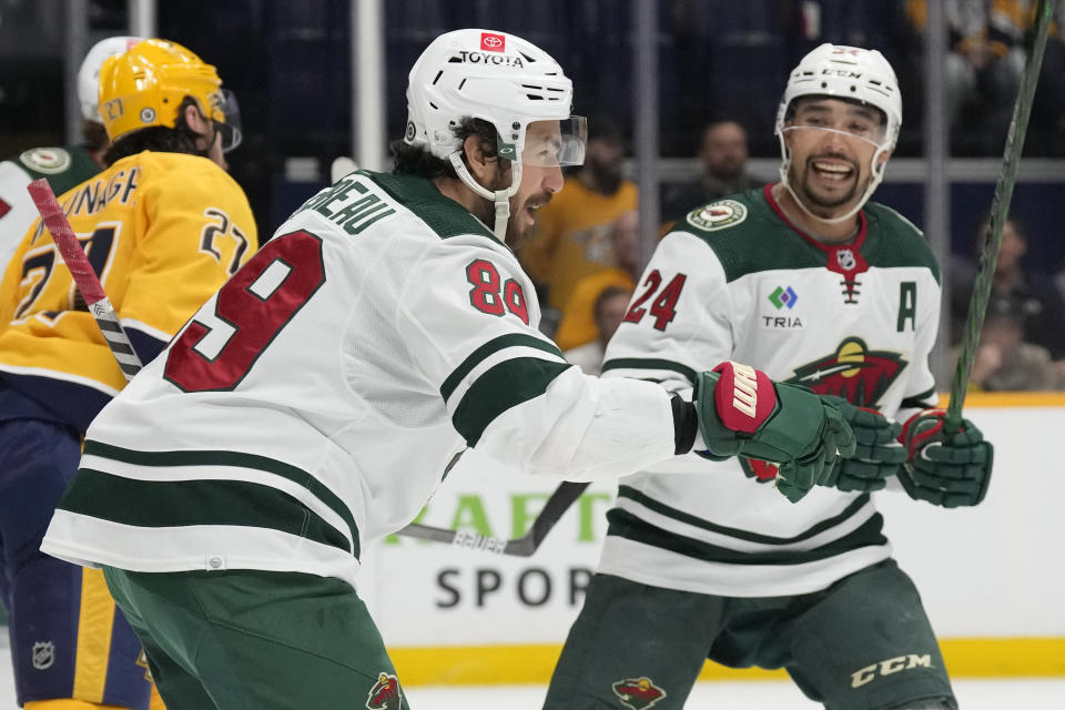 Minnesota Wild center Frederick Gaudreau (89) celebrates with Matt Dumba (24) after scoring against the Nashville Predators during the first period of an NHL hockey game Thursday, April 13, 2023, in Nashville, Tenn. (AP Photo/Mark Humphrey)