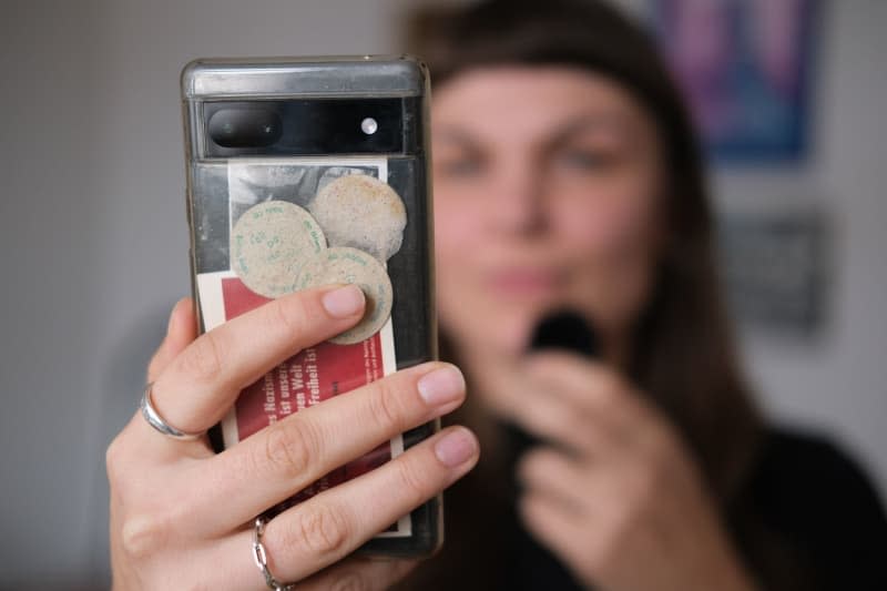 Susanne Siegert counteracts hate speech and disinformation that often circulate on TikTok by raising awareness. Here she holds a mobile phone and a microphone, making a video. Sebastian Willnow/dpa