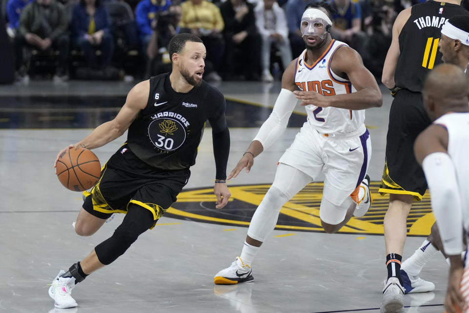 Golden State Warriors guard Stephen Curry (30) drives to the basket against Phoenix Suns forward Josh Okogie (2) during the first half of an NBA basketball game in San Francisco, Monday, March 13, 2023. (AP Photo/Jeff Chiu)