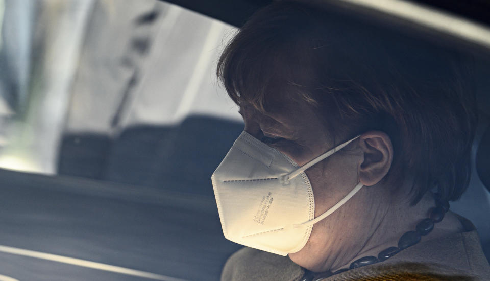 German Chancellor Angela Merkel sits in a car, leaving the Federal Press Conference building after a press conference on the current situation in Berlin, Germany, Thursday, Jan. 21, 2021. Topics included the decisions of the federal and state governments to combat the Corona pandemic, the Chancellor's upcoming virtual consultations with the heads of state and government of the European Union (EU), and relations with the United States following the inauguration of the new president. (Bernd von Jutrczenka/dpa via AP)