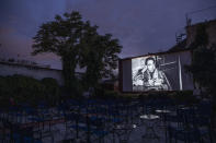 In this Monday June 1, 2020 photo, actor Anthony Quinn is shown on the screen in La Strada, a 1954 Italian drama film directed by Federico Fellini at the Zephyros open-air cinema that specializes in films from past decades in Athens' central Petralona district, on the first day it opened after the easing of Greece's coronavirus lockdown. (AP Photo/Petros Giannakouris)