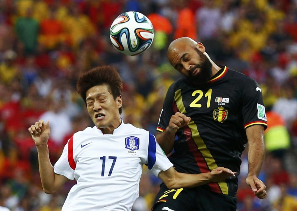 South Korea's Chung-yong jumps for the ball with Belgium's Vanden Borre during their 2014 World Cup Group H soccer match at the Corinthians arena in Sao Paulo